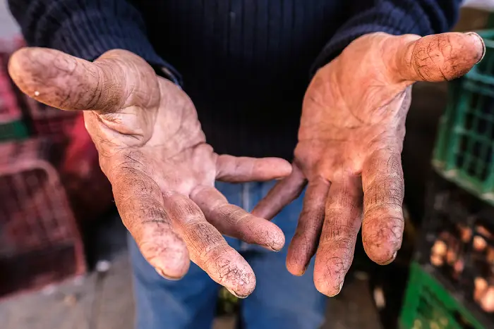 Detalle de las manos de un feriante en el fotolibro 0,99 € de Jaume Parera.
