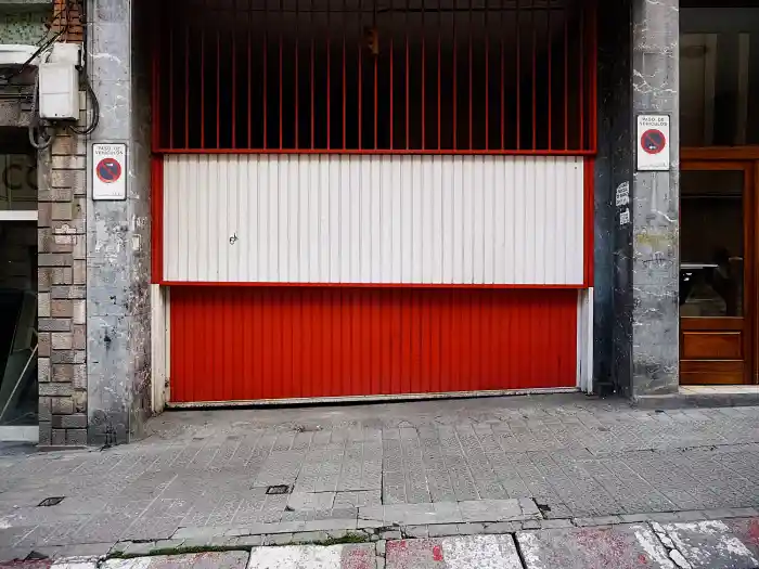 Garaje con la puerta pintada a rayas rojas y blancas en el interior del fotolibro "Mil rayas" de Toni Tena.