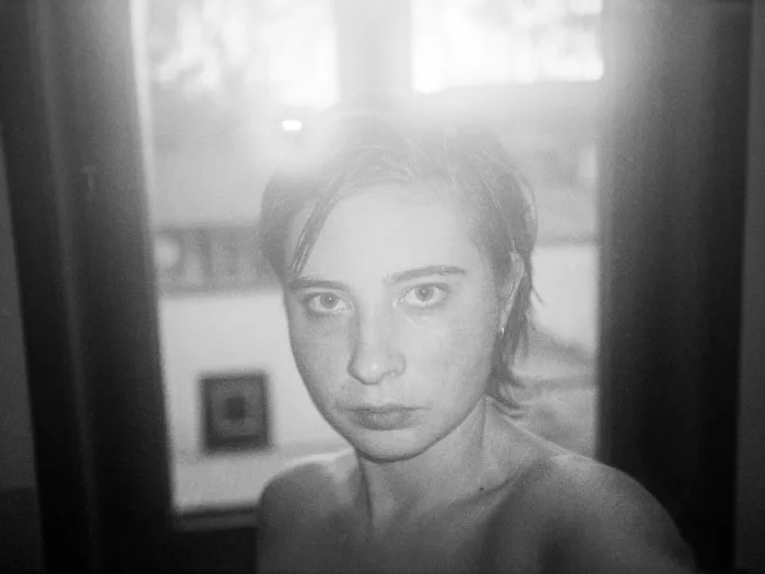 Retrato de una mujer joven en blanco y negro en el interior del fotolibro "In camera" de Arian Christiaens.