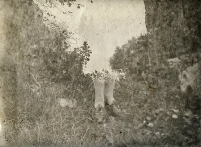 Detalle de las piernas de una mujer en medio de la naturaleza en el interior del fotolibro Ctonio de Alessandra Calò.